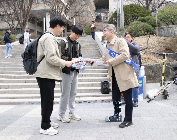 유철호 대한출판문화협회 회장이 학생들에게 불법복제 근절 유인물을 나눠주고 있다.